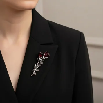 Broszka Róża wpięta w klapę czarnej marynarki damskiej